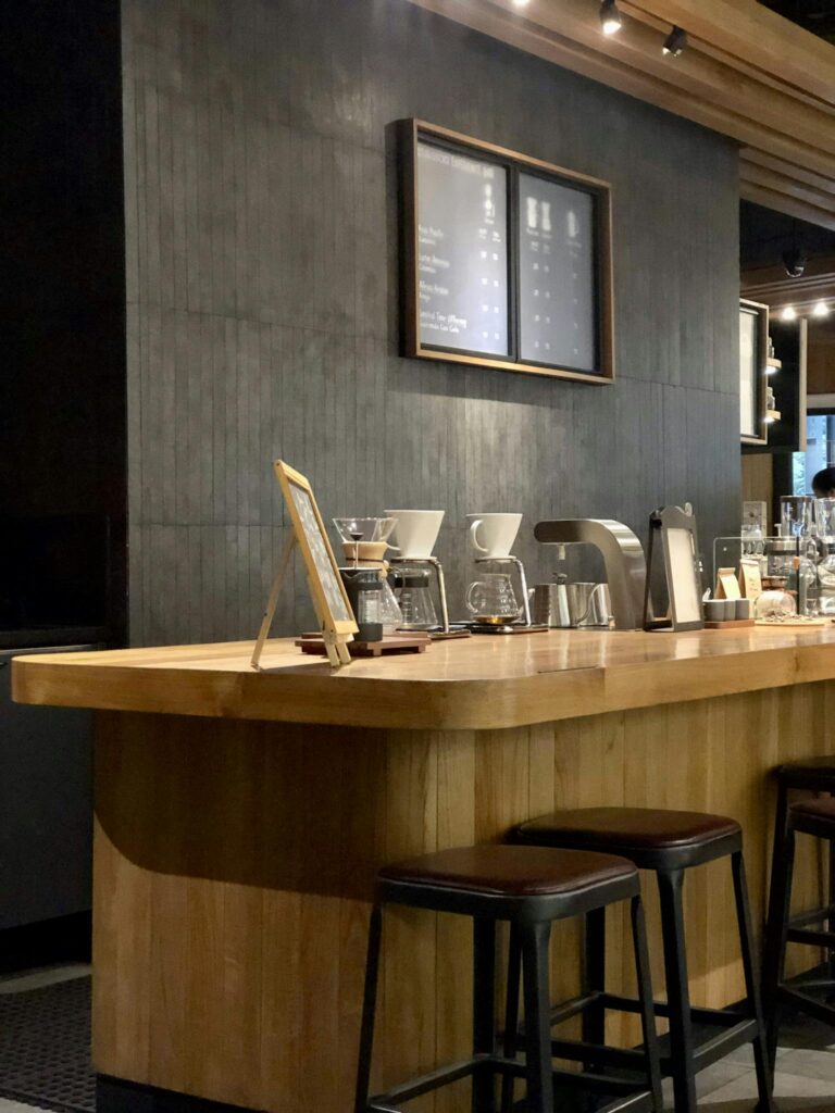 Cozy café interior featuring a modern wooden counter and stylish stools for a relaxed ambiance.